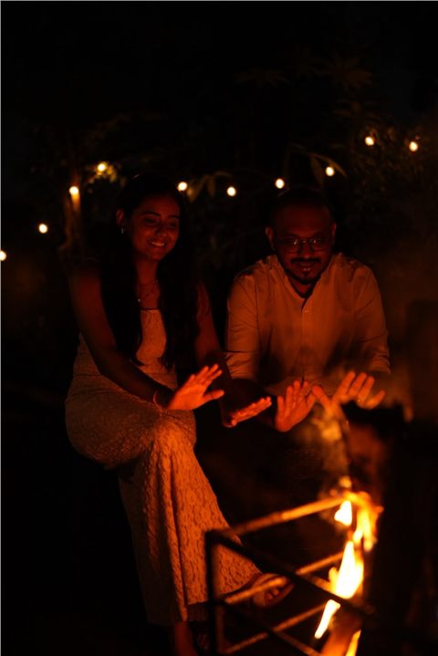 Akshay and Hansa sharing a quiet moment beside the fire