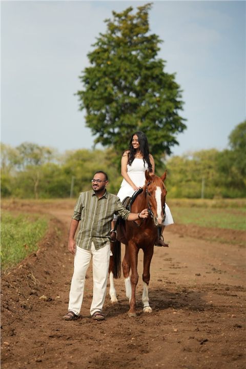 Akshay and Hansa posing with a horse in the countryside