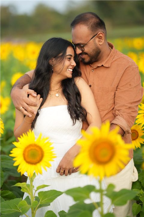 Akshay and Hansa sharing a tender moment in a sunflower field